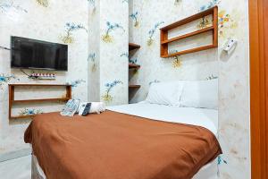a bedroom with a bed with a television on the wall at Queen Residence Ancol RedPartner in Jakarta