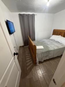 a small bedroom with a bed and a television at Downtown Taylor Room 4 in Phoenix