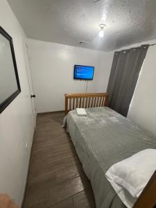 a bedroom with a bed and a tv on the wall at Downtown Taylor Room 4 in Phoenix +2 photos