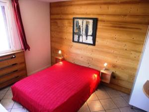 a bedroom with a red bed in a wooden wall at Résidence Marmottes Ii - 3 pièces 6 personnes MAE-2780 in Orcières