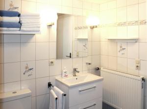 a white bathroom with a sink and a mirror at Ferienwohnung Alexandra in Mettlach +36 photos