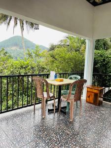a table and chairs on a balcony with a view at The Grand Residence in Ella