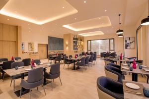 a restaurant with tables and chairs and a chalkboard at Keys Select By Lemon Tree Hotels, Vadodara in Vadodara