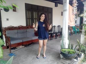 a woman standing in a room giving the thumbs up at ADOBE AFFECTIOn in Tangalle