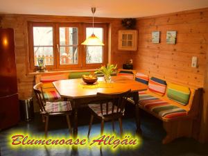 a dining room with a wooden table and chairs at Blumenoase Allgäu in Schwanden