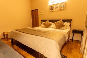 a bedroom with a large bed with white sheets and pillows at The Leafyard Container Home in Venkatāpur