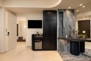 a bathroom with a sink and a counter with a television at Elounda Stories Boutique Hotel in Elounda