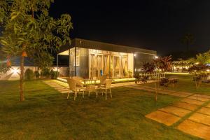 a house with a table and chairs outside at night at The Leafyard Container Home in Venkatāpur +19 photos
