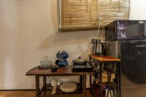 a kitchen with a table with a stove and a tv at The Leafyard Container Home in Venkatāpur