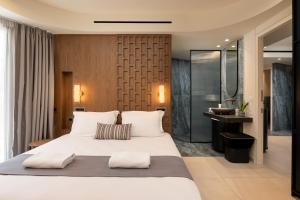 a bedroom with a large bed and a bathroom at Elounda Stories Boutique Hotel in Elounda