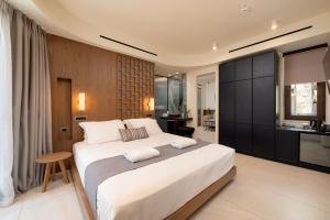 a bedroom with a large white bed and a kitchen at Elounda Stories Boutique Hotel in Elounda +87 photos