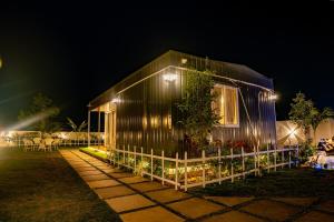 a house with lights on the side of it at night at The Leafyard Container Home in Venkatāpur