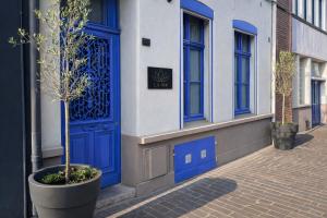 a blue door on the side of a building at Suite Picasso Balnéo et Spa Privatif, Ambiance Arty Chic in Saint-Omer
