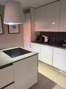 a kitchen with white cabinets and a black counter top at La Cosette Janvier in Mios