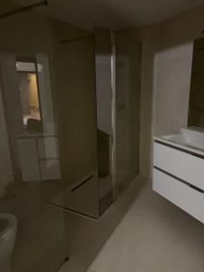 a bathroom with a glass shower and a toilet at La Cosette Janvier in Mios