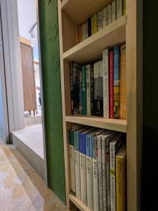 a book shelf filled with books next to a door at Hostel x Hair ie in Hadano