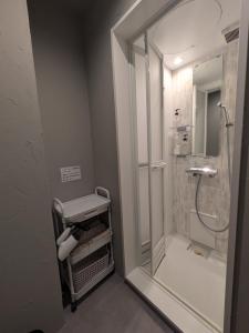 a bathroom with a shower with a glass door at Hostel x Hair ie in Hadano +31 photos