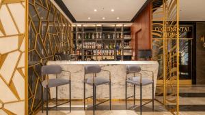 a bar in a hotel lobby with stools at Teymur Continental Hotel in Gaziantep