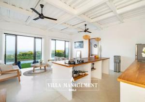 a kitchen with white walls and a ceiling fan at Villa Maracuya in Pecatu Bali - Spacious 3 Bedroom with Pool in Badung
