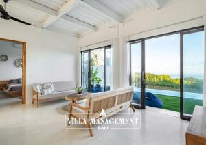 a living room with large windows and a couch at Villa Maracuya in Pecatu Bali - Spacious 3 Bedroom with Pool in Badung