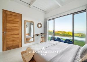 a bedroom with a bed and a large window at Villa Maracuya in Pecatu Bali - Spacious 3 Bedroom with Pool in Badung