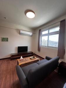 a living room with a couch and a table at Kinmen Xinya Homestay in Jinning