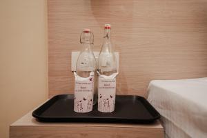 two bottles sitting on a tray next to a bed at Alpine Retreat in Narendranagar
