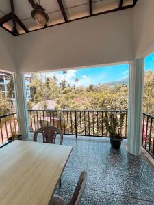 a dining room with a table and chairs and a balcony at The Grand Residence in Ella