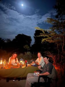 a group of people sitting around a table at night at Jungle Cabin - Bundala in Bundala Levagamgoda +51 photos