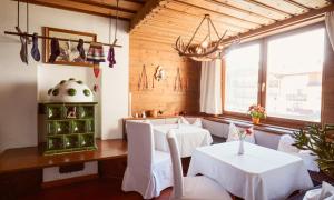 a dining room with white tables and white chairs at Hotel Enzian by Alpeffect Hotels in Zauchensee