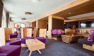 a room with purple furniture and a flat screen tv at Hotel Enzian by Alpeffect Hotels in Zauchensee