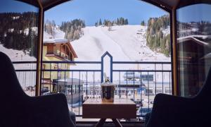 a room with a view of a ski slope through a window at Hotel Enzian by Alpeffect Hotels in Zauchensee