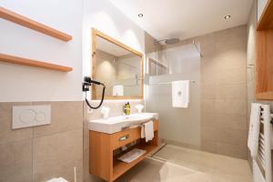 a bathroom with a sink and a mirror at Hotel Trattlerhof in Bad Kleinkirchheim