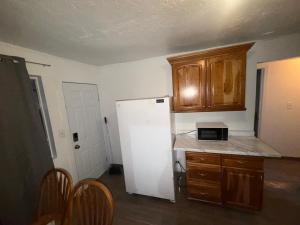 a kitchen with a white refrigerator and wooden cabinets at Downtown Taylor Room 4 in Phoenix