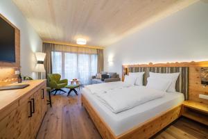 a bedroom with a large white bed in a room at Hotel Trattlerhof in Bad Kleinkirchheim