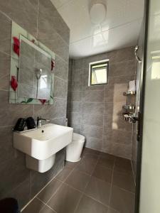 a bathroom with a sink and a toilet at De Pakha Homestay in Bắc Hà