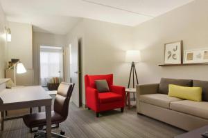 a living room with a couch and a red chair at Country Inn & Suites by Radisson, Champaign North, IL in Champaign +29 photos