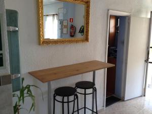 un mostrador en una habitación con dos taburetes bajo un espejo en Hostal San Telmo, en Palma de Mallorca