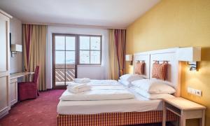 a hotel room with two beds and a window at Hotel Enzian by Alpeffect Hotels in Zauchensee +36 photos