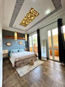 a bedroom with a large bed and a ceiling at Zeri Surf Taghazout Hiltop in Taghazout