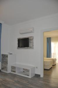 a living room with a tv on a white wall at Nur Hotel in Kaş