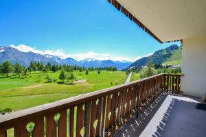 a balcony with a view of a field and mountains at Hollandia 26 in Riederalp