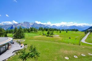 an aerial view of a golf course with mountains in the background at Hollandia 26 in Riederalp