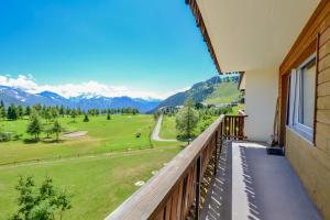 a balcony with a view of a golf course at Hollandia 26 in Riederalp