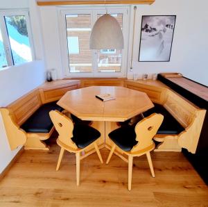 a dining room with a wooden table and chairs at Hollandia 26 in Riederalp +10 photos