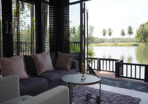 a living room with a couch and a view of a lake at Base 22 Hatyai in Ban Rai