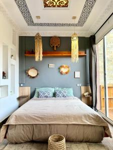 a bedroom with a bed and a blue wall at Zeri Surf Taghazout Hiltop in Taghazout