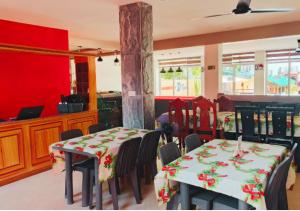 D'Resort Beach Resort في Zambales: غرفة طعام بها طاولتان وكراسي وجدران حمراء