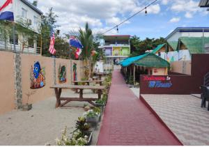 D'Resort Beach Resort في Zambales: رصيف بجوار مبنى به مقعد خشبي