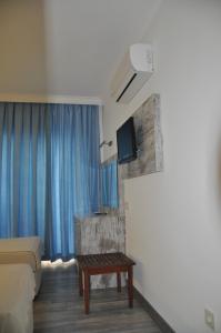a hotel room with a bed and a table and a tv at Nur Hotel in Kaş